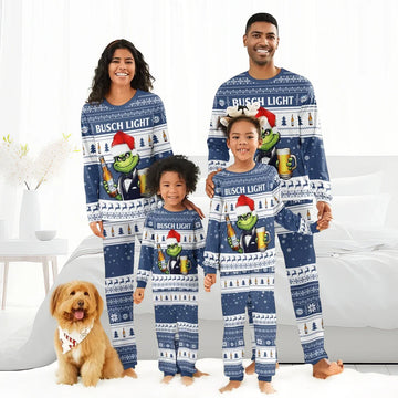 Family of four wearing matching blue Busch Light Christmas pajamas with Grinch and beer design, standing barefoot indoors with a dog
