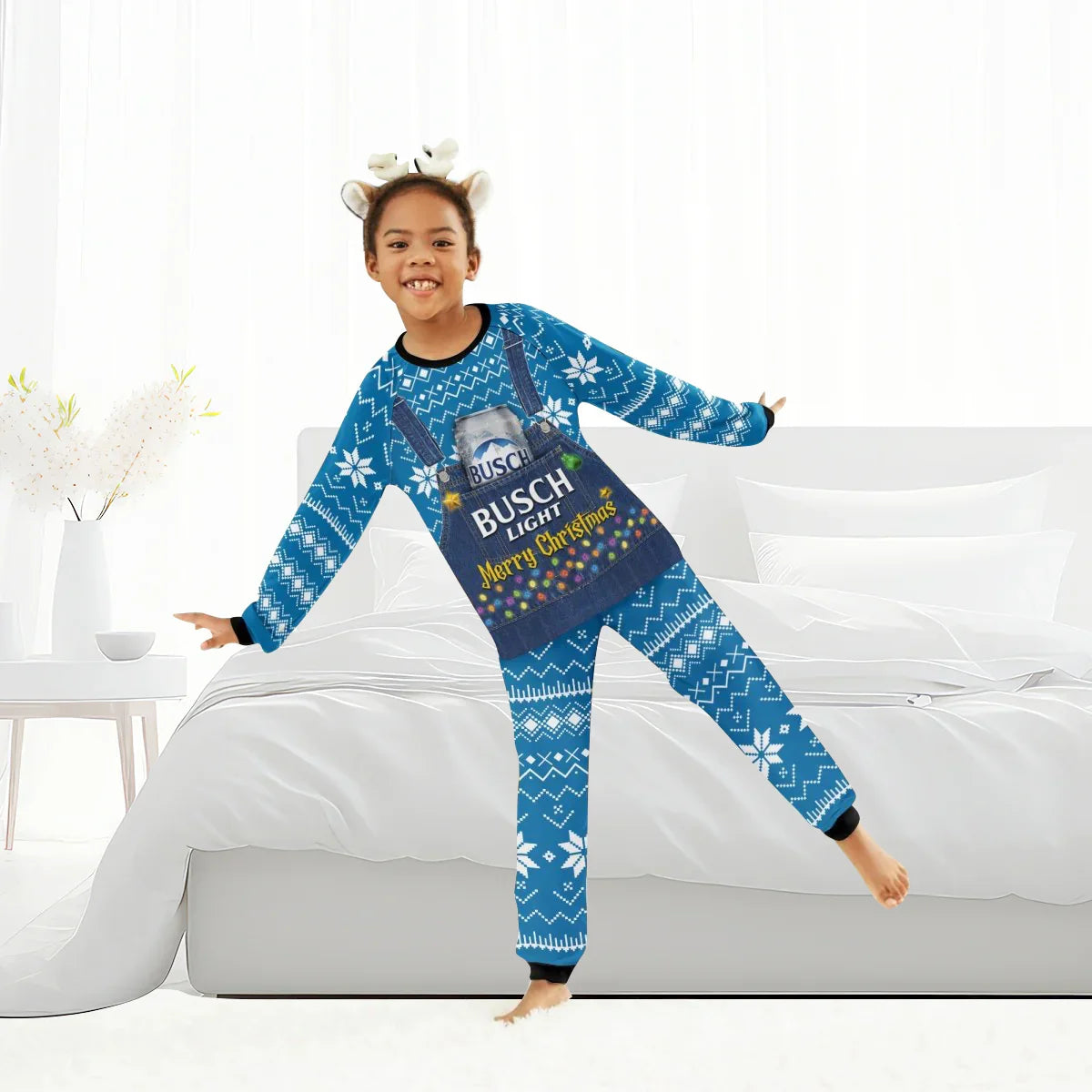 Child wearing blue Busch Light Merry Christmas family pajamas with snowflake pattern and antler headband