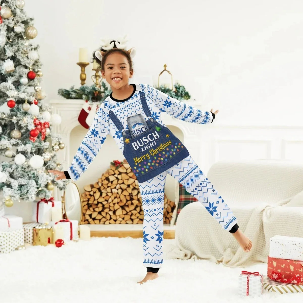 Smiling child in blue and white Busch Light Merry Christmas pajamas with reindeer antlers by decorated Christmas tree