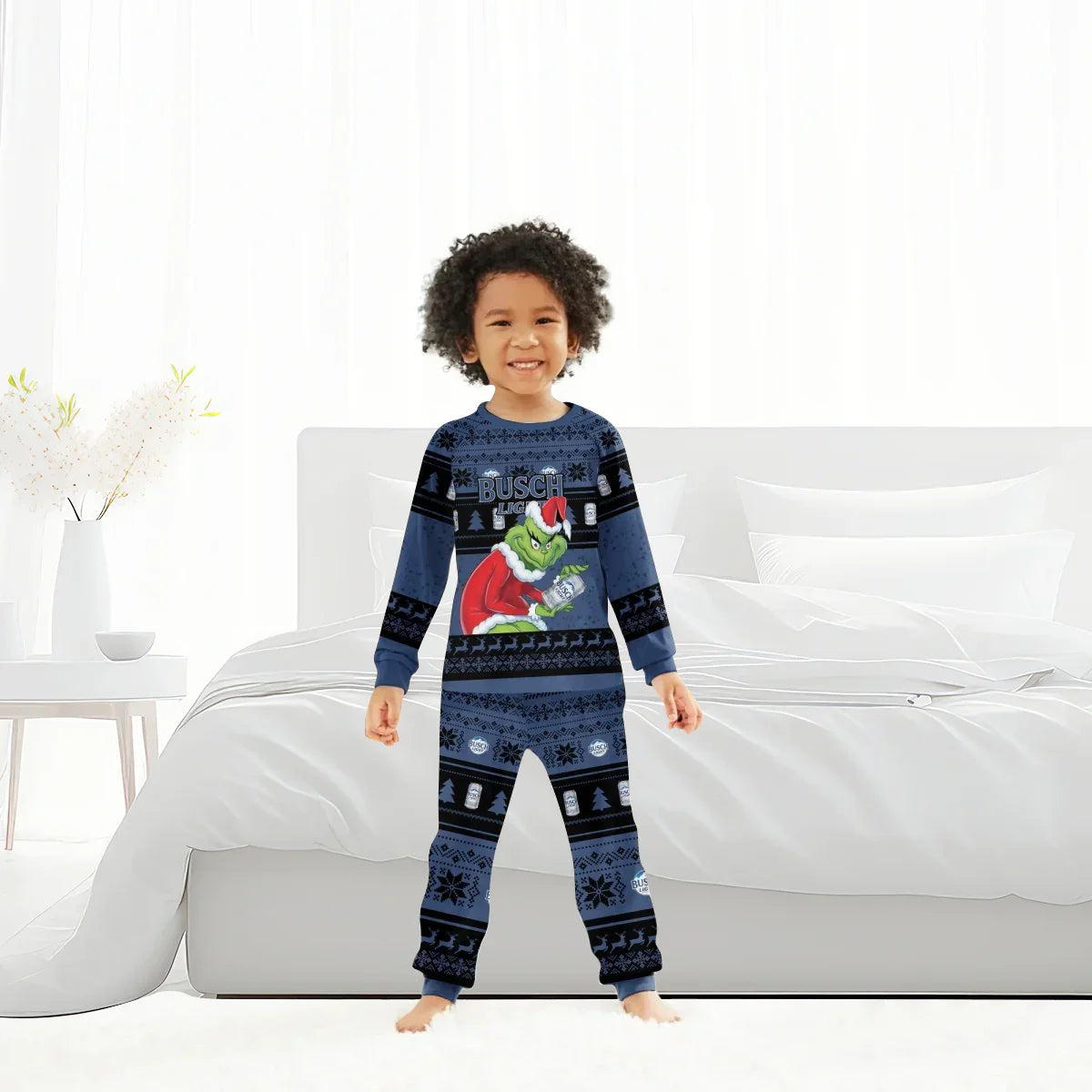 Child wearing blue Busch Light Grinch Christmas pajamas standing barefoot in a bright bedroom