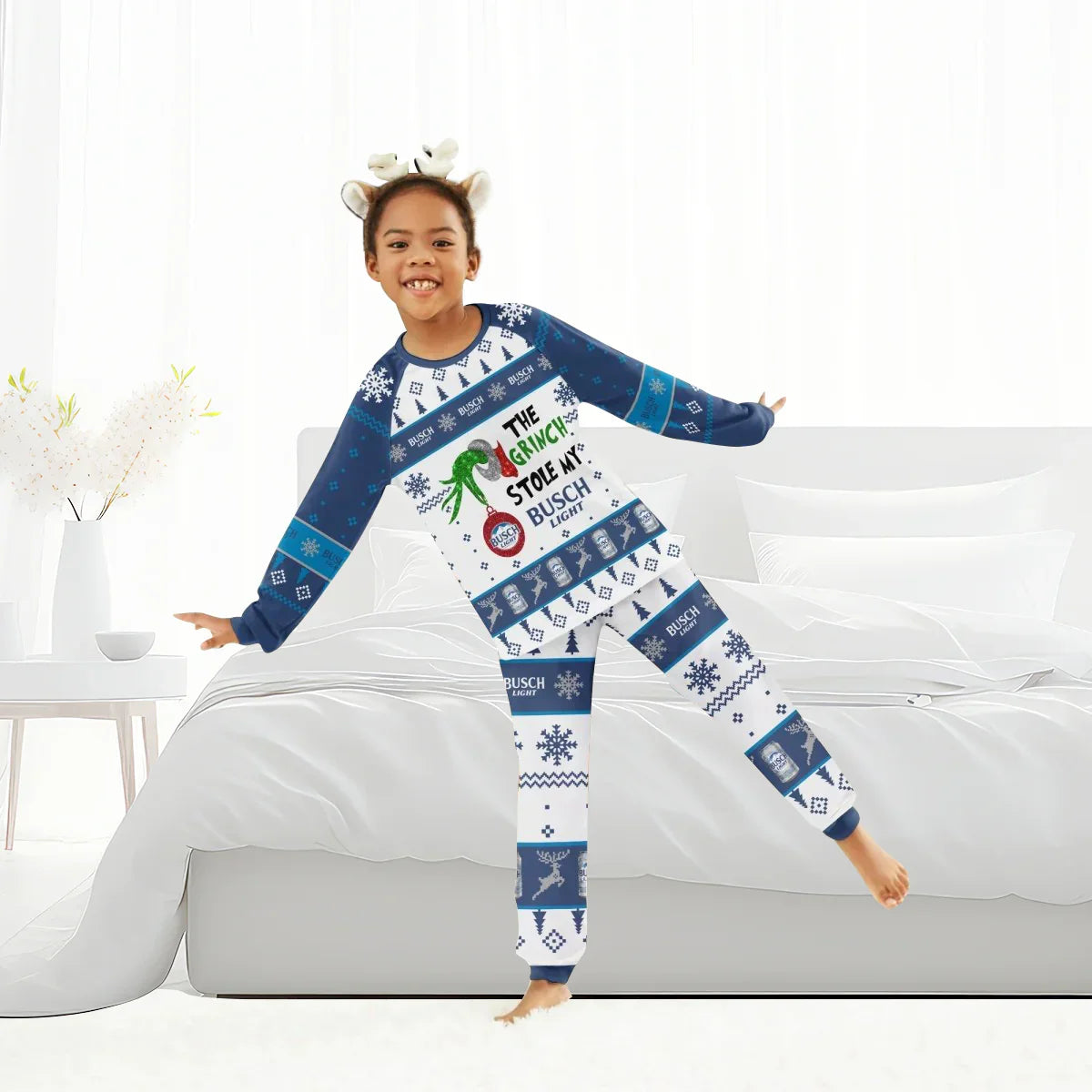 Child in festive blue and white Grinch-themed Busch Light pajamas posing in bright bedroom