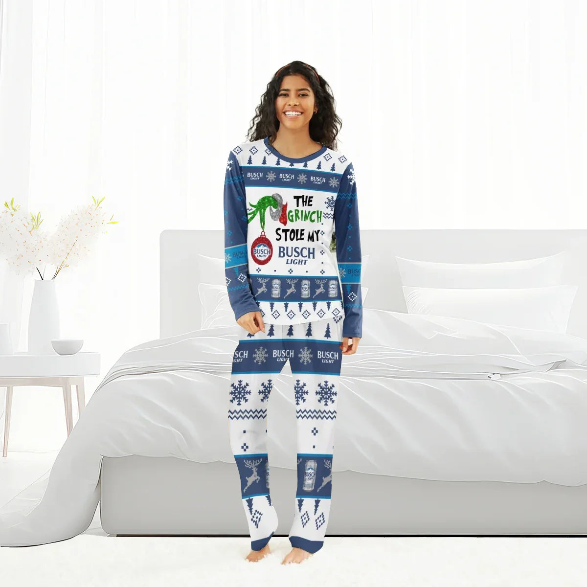 Smiling woman in blue and white Christmas pajamas with Grinch and Busch Light holiday design