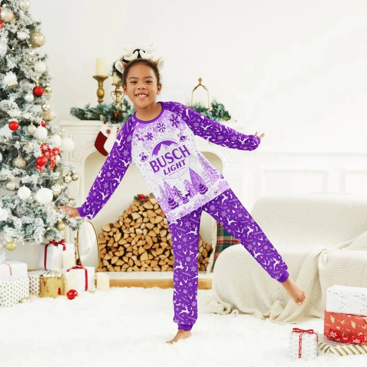 Happy girl wearing purple Busch Light Christmas pajamas and reindeer antler headband in festive living room