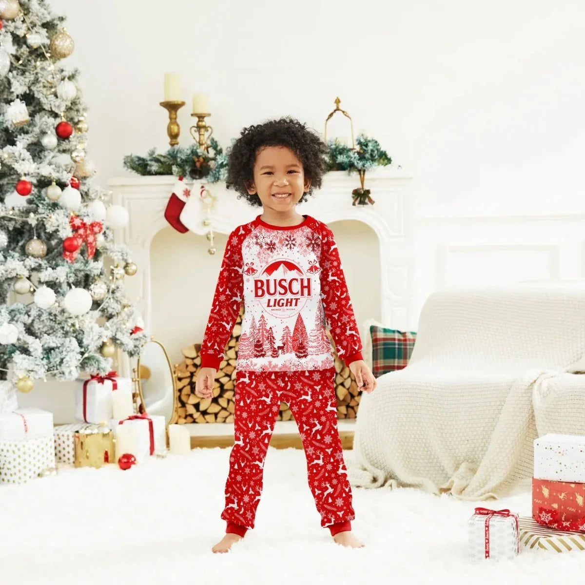 Child wearing red Busch Light Christmas pajamas in festive living room with tree, gifts, and fireplace