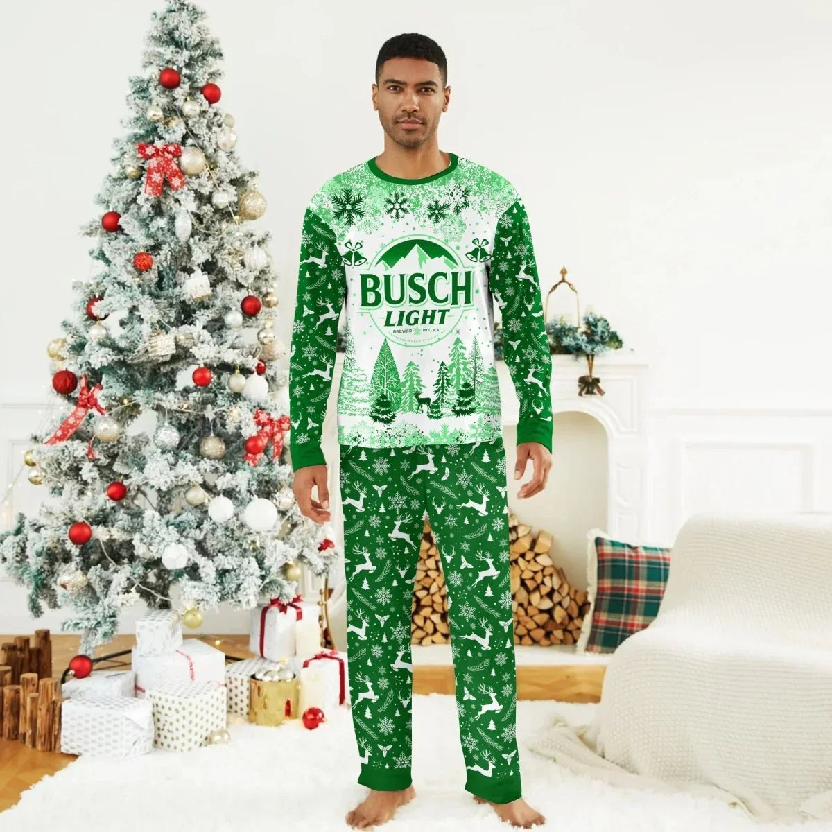 Man wearing green and white Busch Light Christmas pajamas with reindeer and snowflakes by decorated Christmas tree