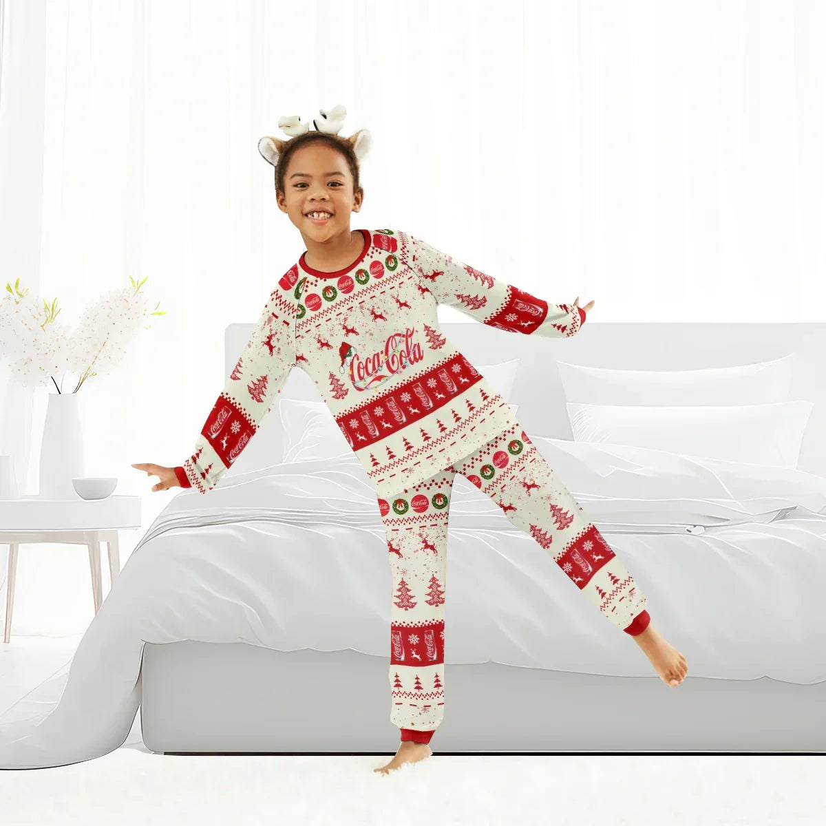 Child in Coca-Cola Christmas reindeer family pajamas with festive red and white patterns in bright bedroom