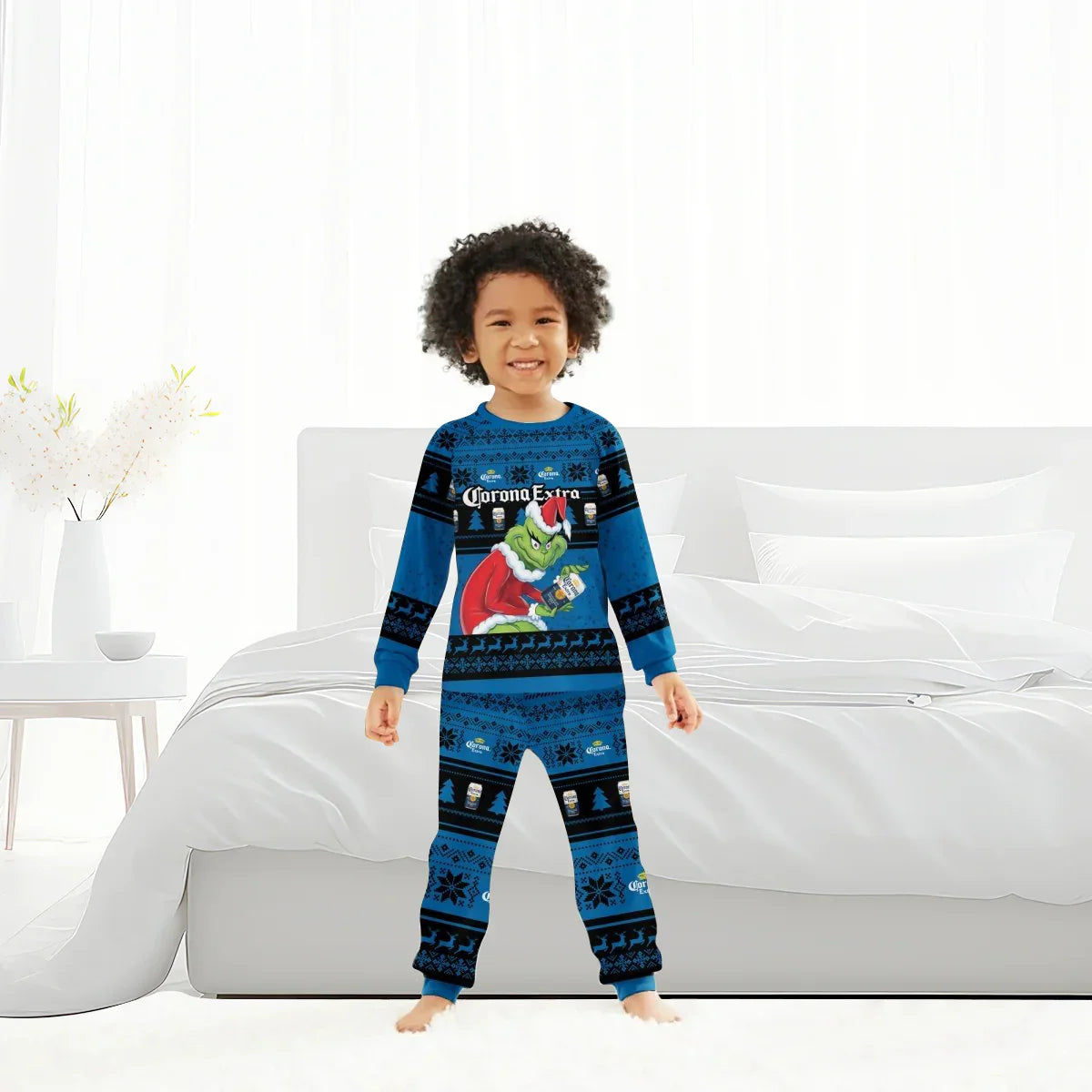 Smiling child in blue Corona Extra and Grinch Christmas pajama set standing in modern white bedroom
