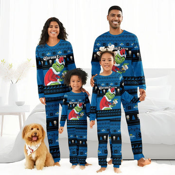 Family wearing matching blue Corona Extra Grinch Christmas pajamas in a bedroom with a dog