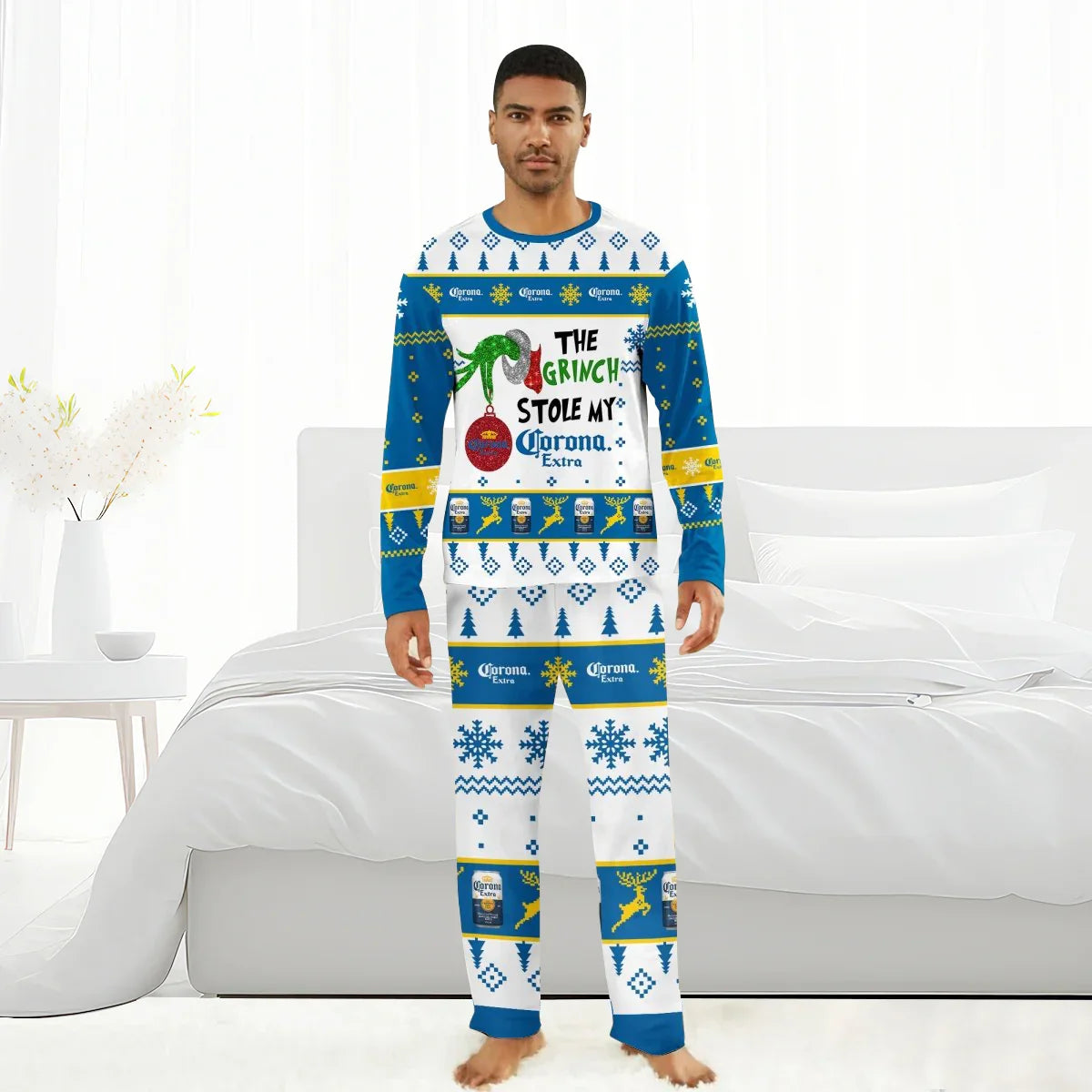 Man in Christmas-themed Corona Extra pajama set with Grinch and holiday graphics in white bedroom