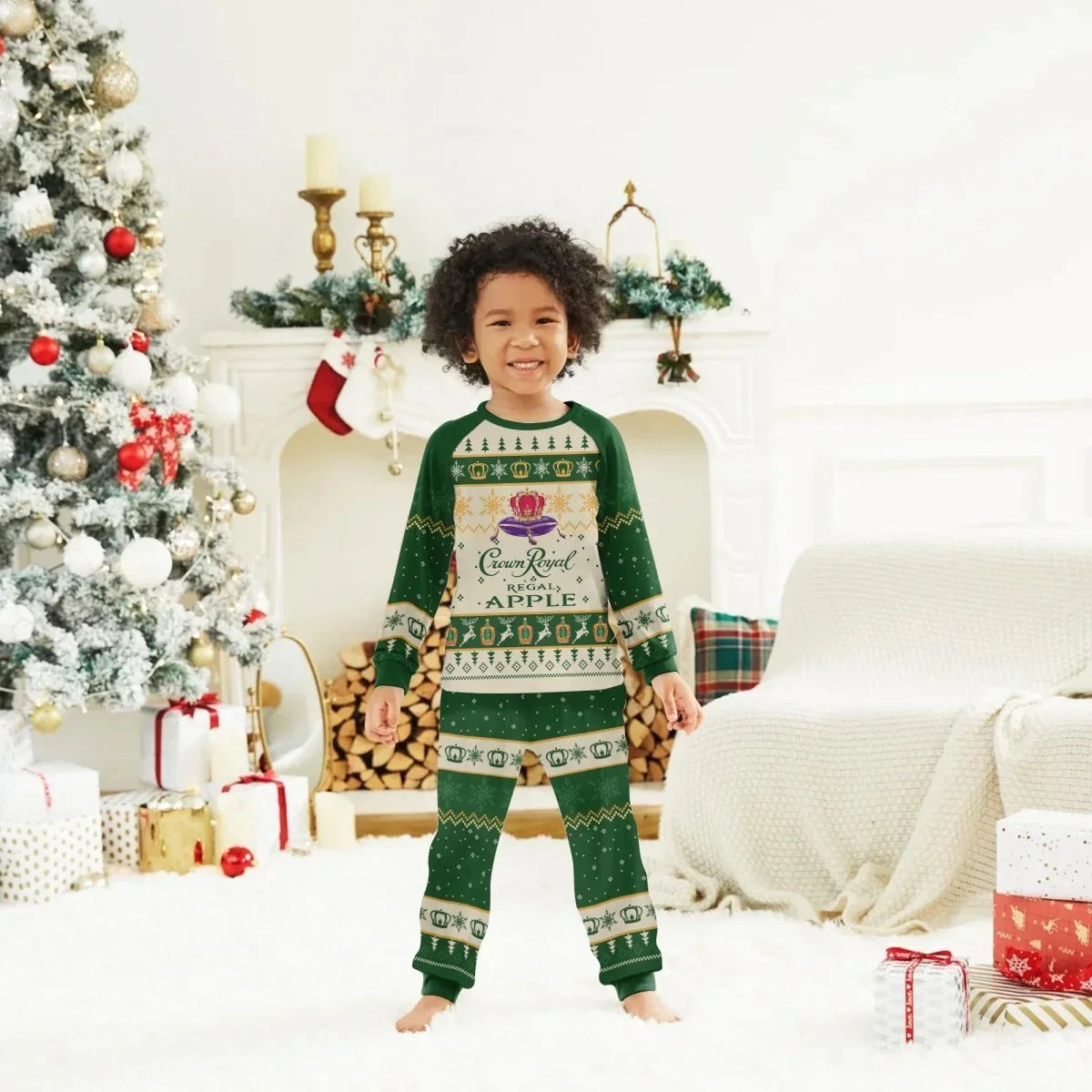 Smiling child in green Crown Royal Apple Christmas pajamas by decorated tree and fireplace