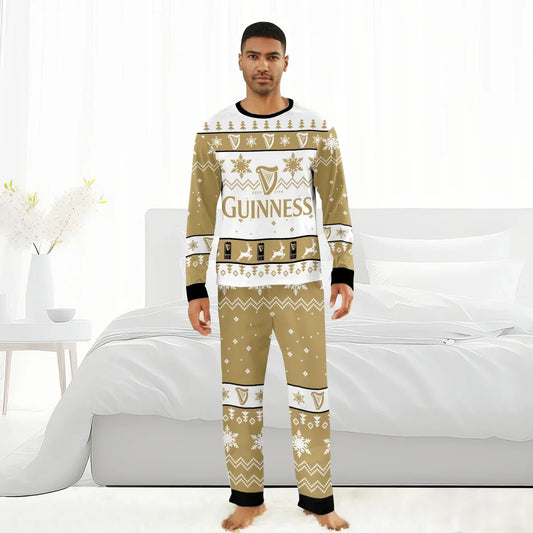 Man wearing beige and white Guinness Christmas holiday pajamas with snowflakes and reindeer, standing barefoot in white bedroom