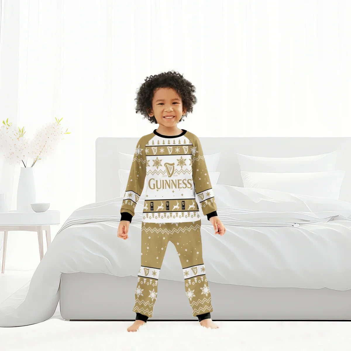 Smiling child in Guinness holiday pajamas standing barefoot in bright white bedroom