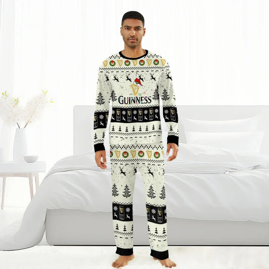 Man wearing white Guinness-themed Christmas pajamas with reindeer, trees, and holiday patterns in a bright bedroom