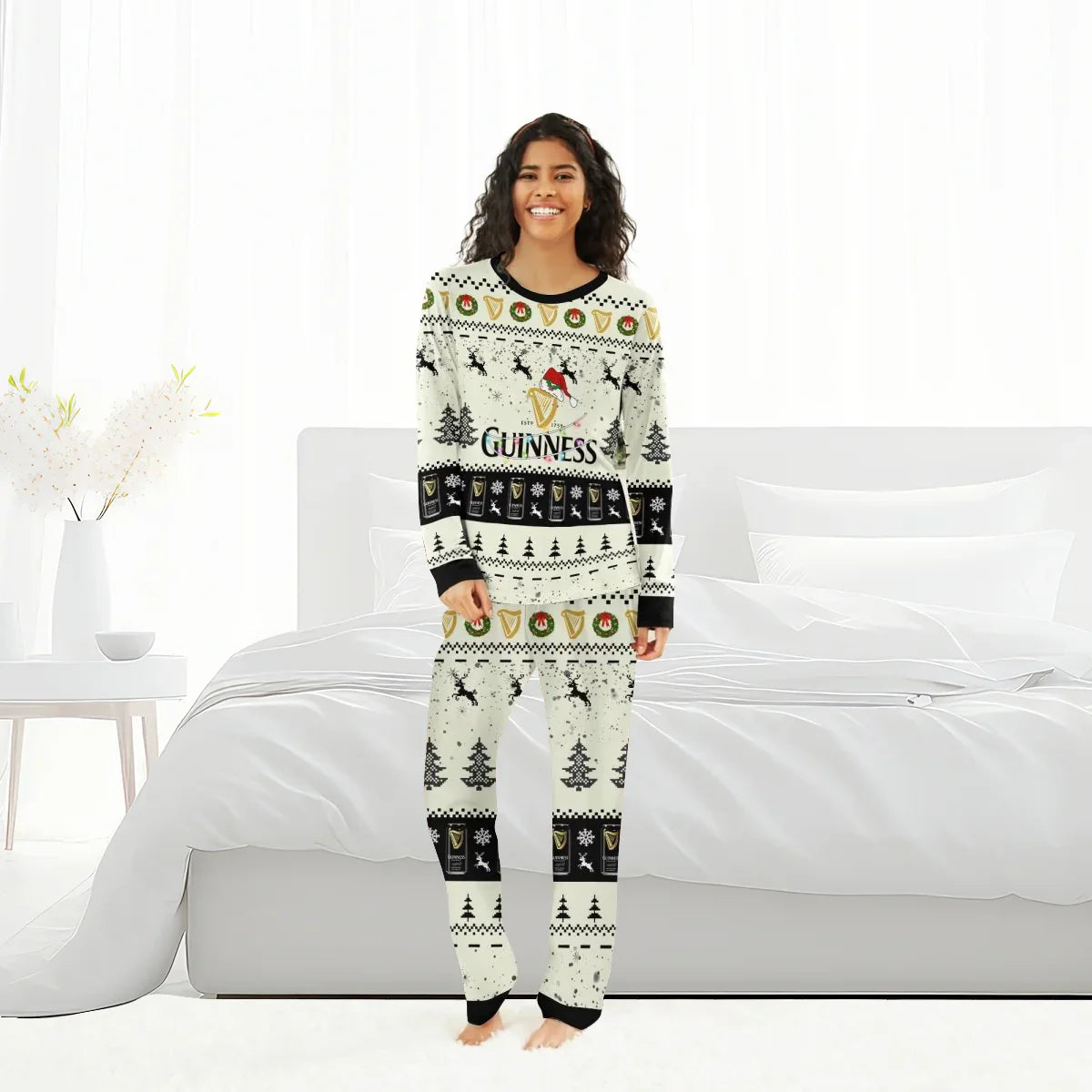 Smiling woman in white festive Guinness Christmas reindeer pajama set standing in bright bedroom