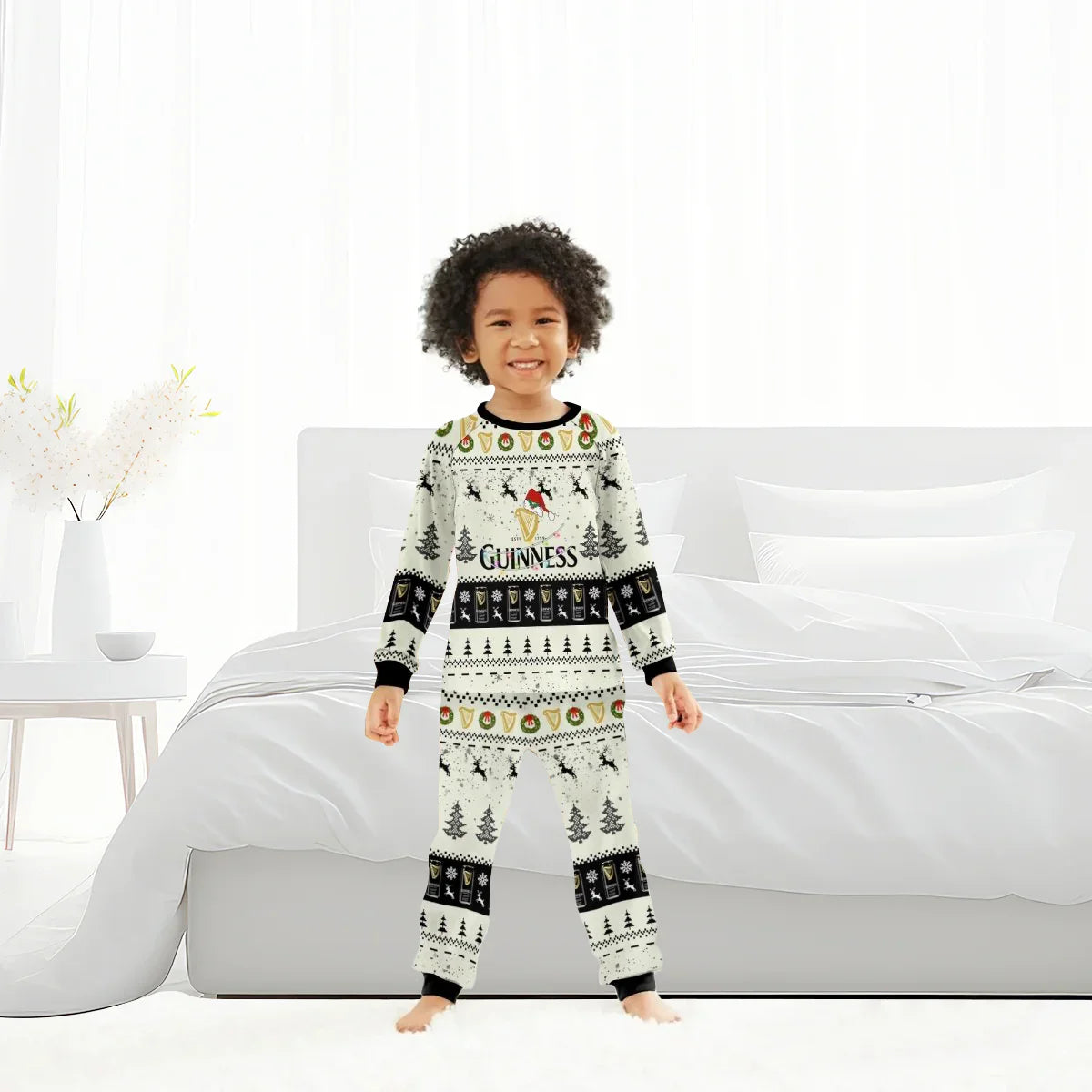 Smiling child wearing Guinness Christmas reindeer family pajamas in bright bedroom