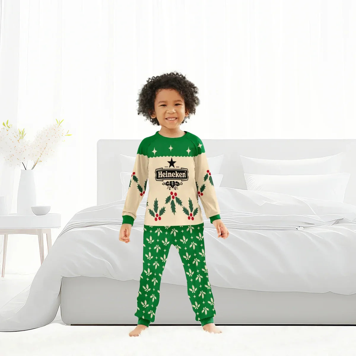 Smiling child wearing green and cream Heineken Christmas pajamas with holly patterns in bright bedroom