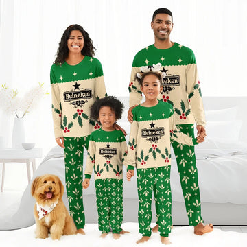 Smiling family of four in matching green and beige Heineken Christmas pajamas with holly patterns in bedroom
