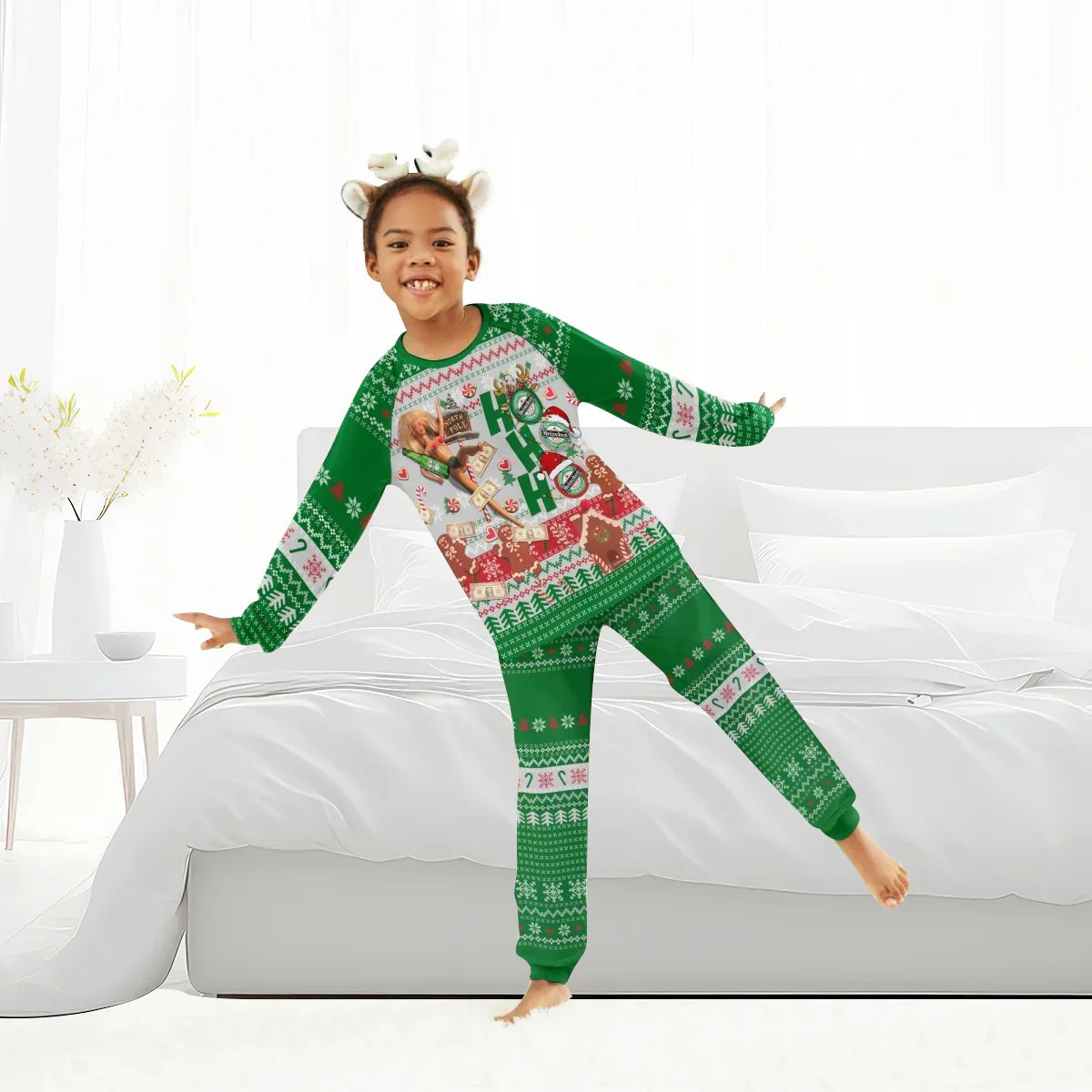 Smiling child wearing green Christmas pajamas with festive patterns and reindeer headband in bright bedroom