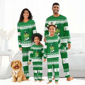 Happy family and dog in green Grinch-themed Christmas pajamas in cozy bright bedroom