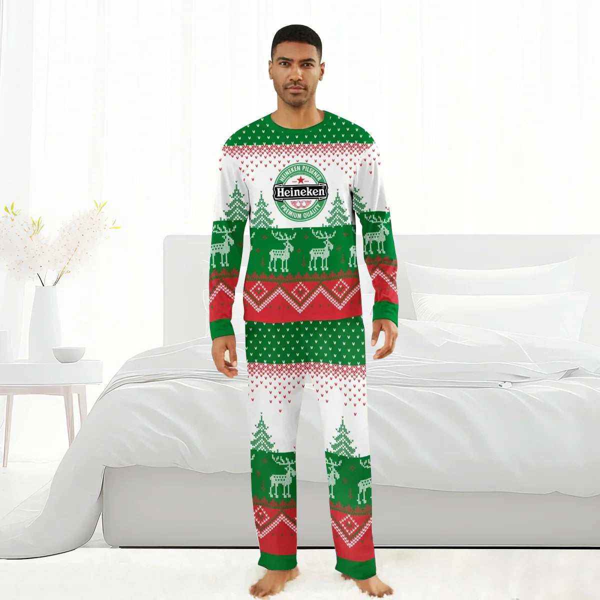Man wearing Heineken branded Christmas pajamas with reindeer and tree patterns in bedroom