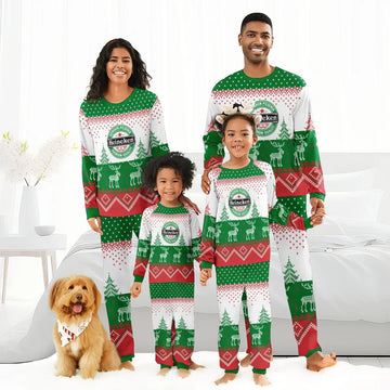 Family in matching Heineken Christmas pajamas with reindeer and Christmas tree patterns, indoor setting with dog