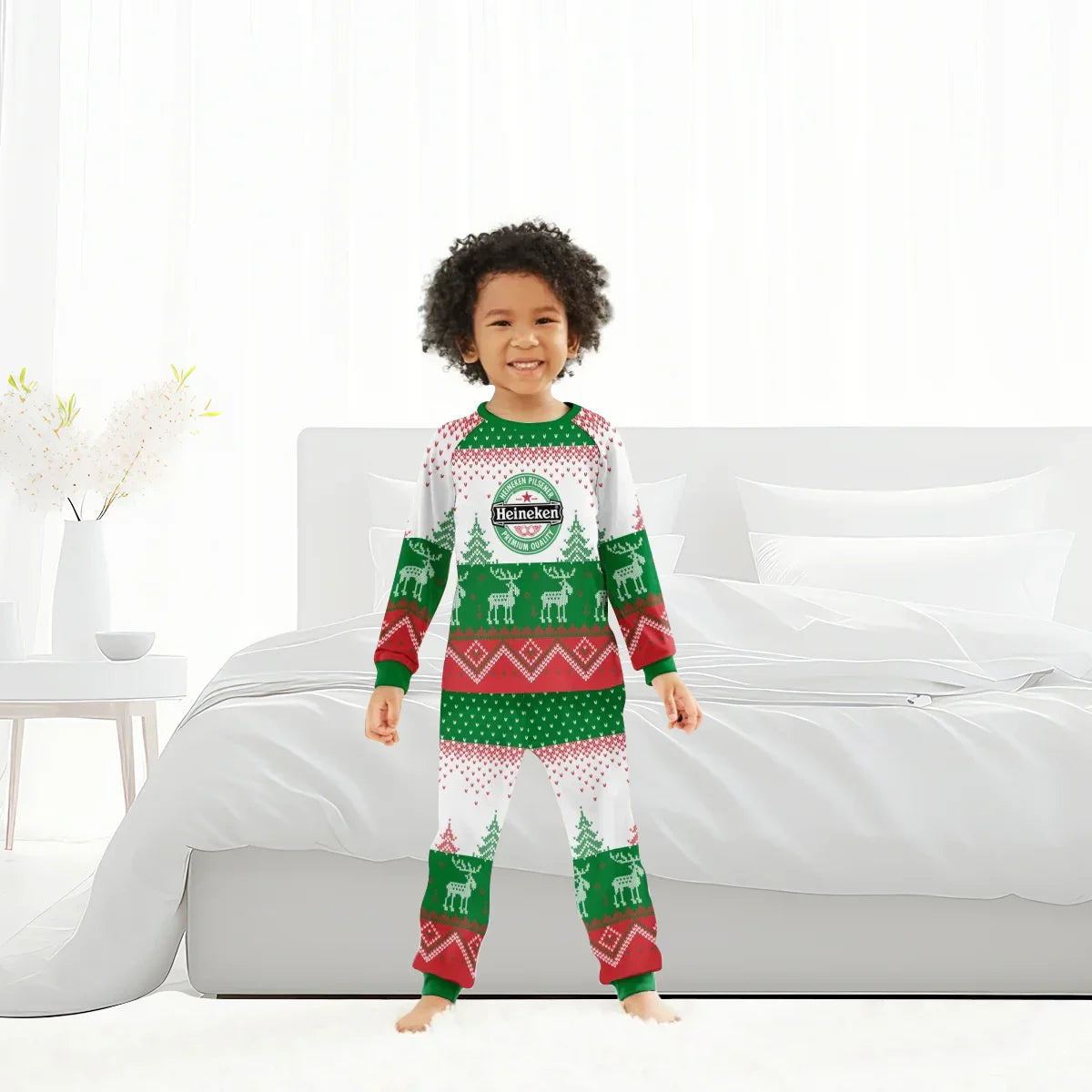 Smiling child in Christmas reindeer pajamas with Heineken logo standing in white bedroom