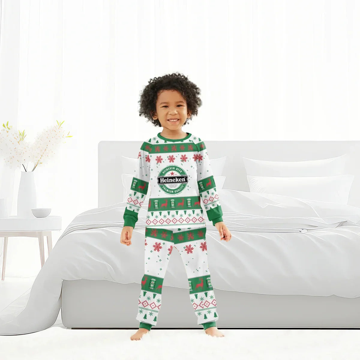 Smiling child wearing white and green Heineken Christmas holiday pajamas standing in bright bedroom
