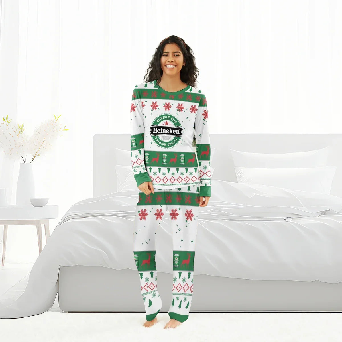 Woman wearing Heineken Christmas holiday pajamas with green, red patterns standing in white bedroom