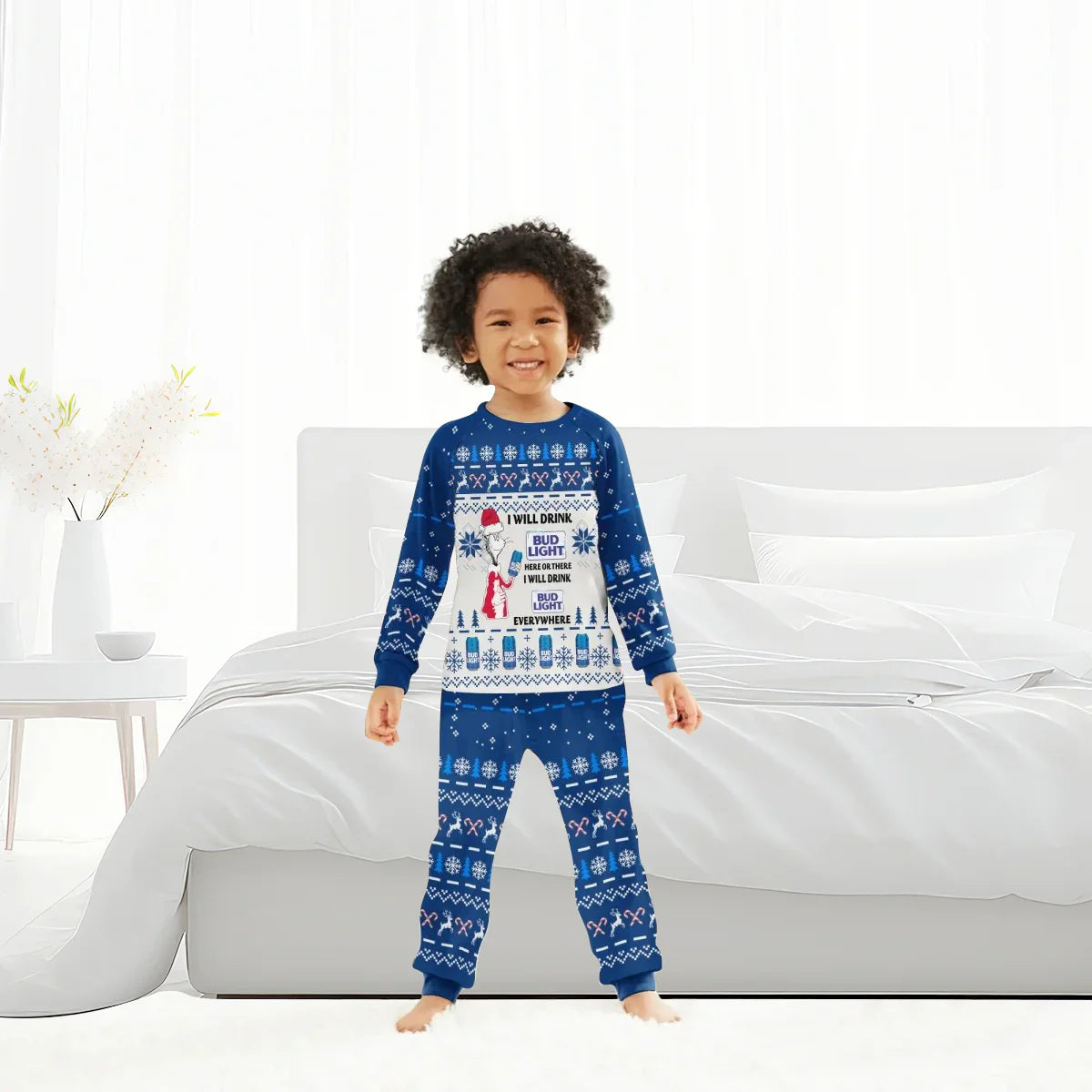Smiling child in blue Bud Light Christmas pajama set with holiday patterns standing in white bedroom
