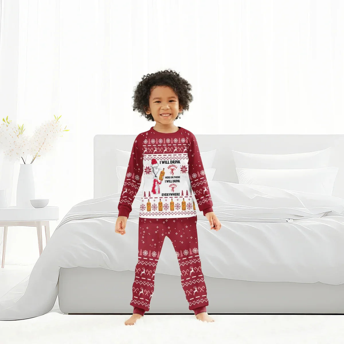 Smiling child in red Christmas pajamas with festive Fireball whiskey holiday design