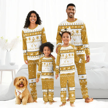 Smiling family in matching gold and white Johnnie Walker Christmas pajamas with festive patterns, standing in bright bedroom