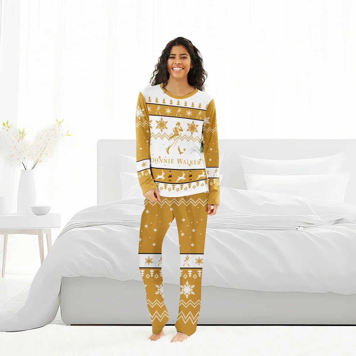 Smiling woman wearing mustard and white Johnnie Walker Christmas pajama set in bright bedroom