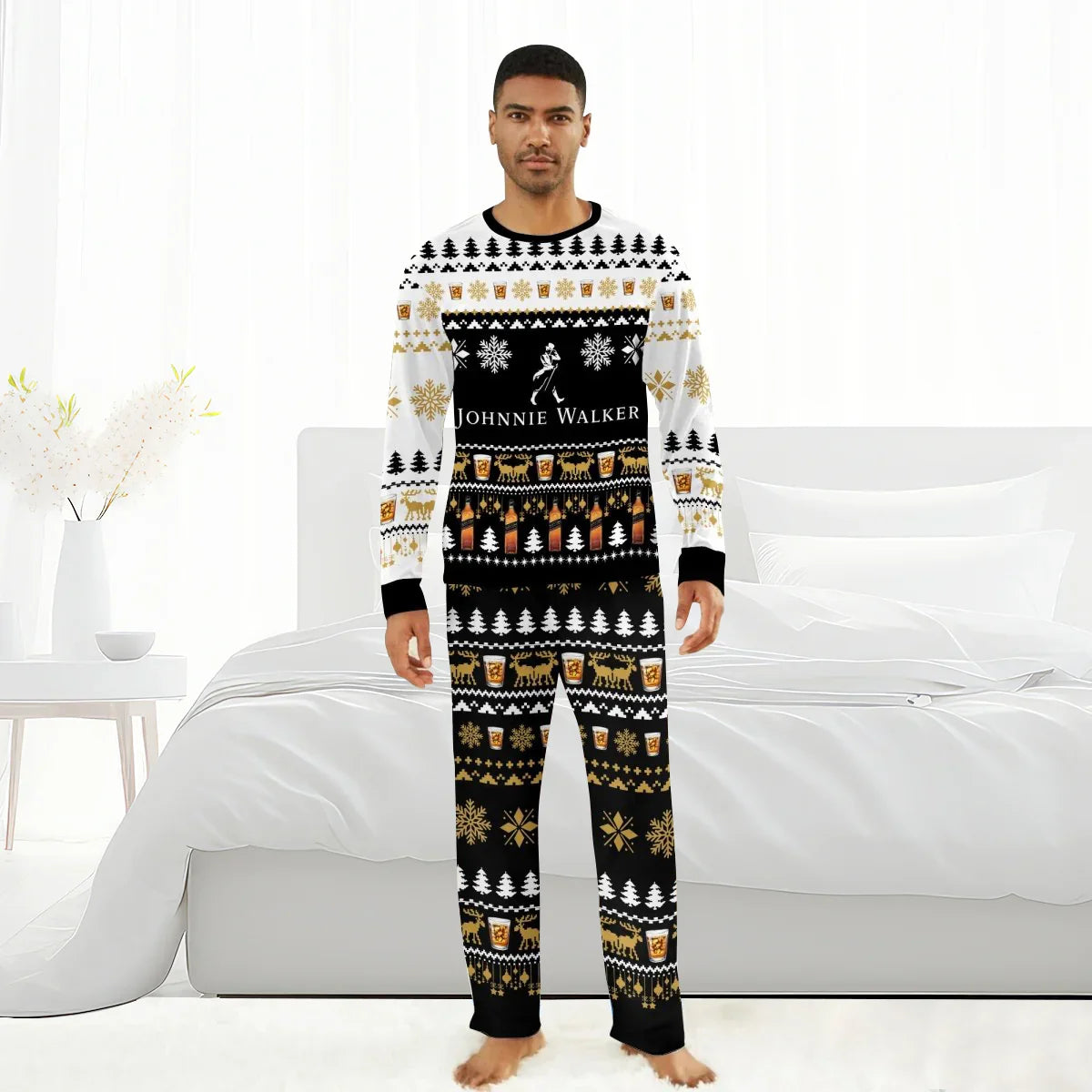 Man wearing black and white Johnnie Walker Christmas-themed pajamas with festive patterns standing in a white bedroom