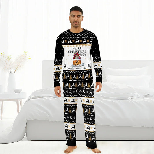 Man wearing black Christmas pajamas with reindeer, trees, and Full of Christmas Spirit Johnnie Walker design, standing barefoot in white bedroom