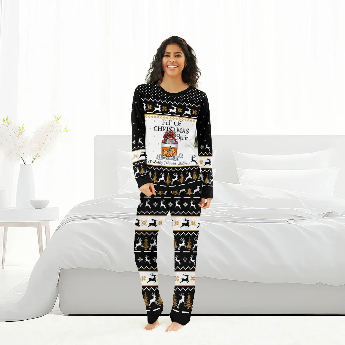Smiling woman in black Christmas pajamas with Full of Christmas Spirit text in bright bedroom