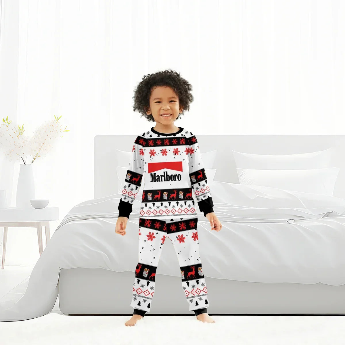 Child wearing Marlboro Christmas holiday pajamas with snowflakes, reindeer, and Santa patterns in modern bedroom
