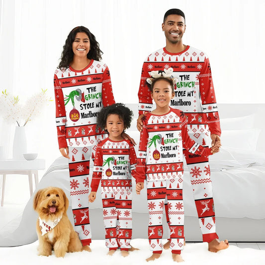 Smiling family in matching red and white Christmas pajamas with Grinch stole Marlboro design next to dog