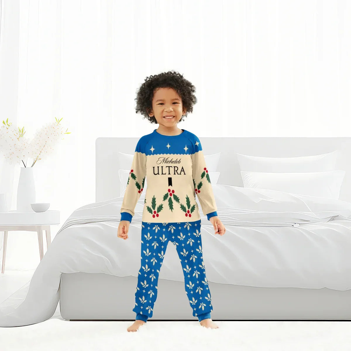 Smiling child wearing blue and cream Michelob Ultra Christmas cherry family pajamas in bright bedroom