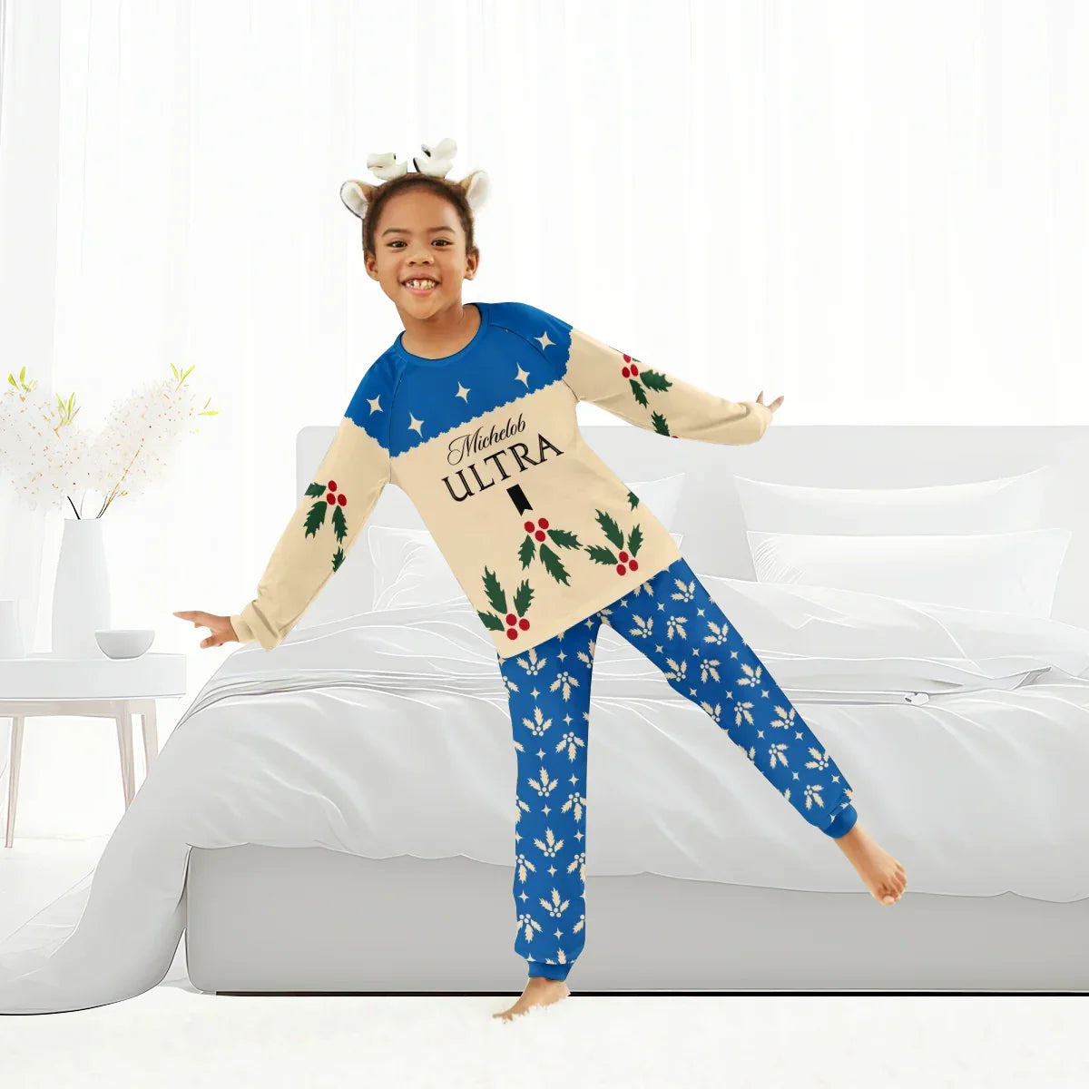Child wearing festive Michelob Ultra holiday pajamas with holly and snowflake prints in bright bedroom