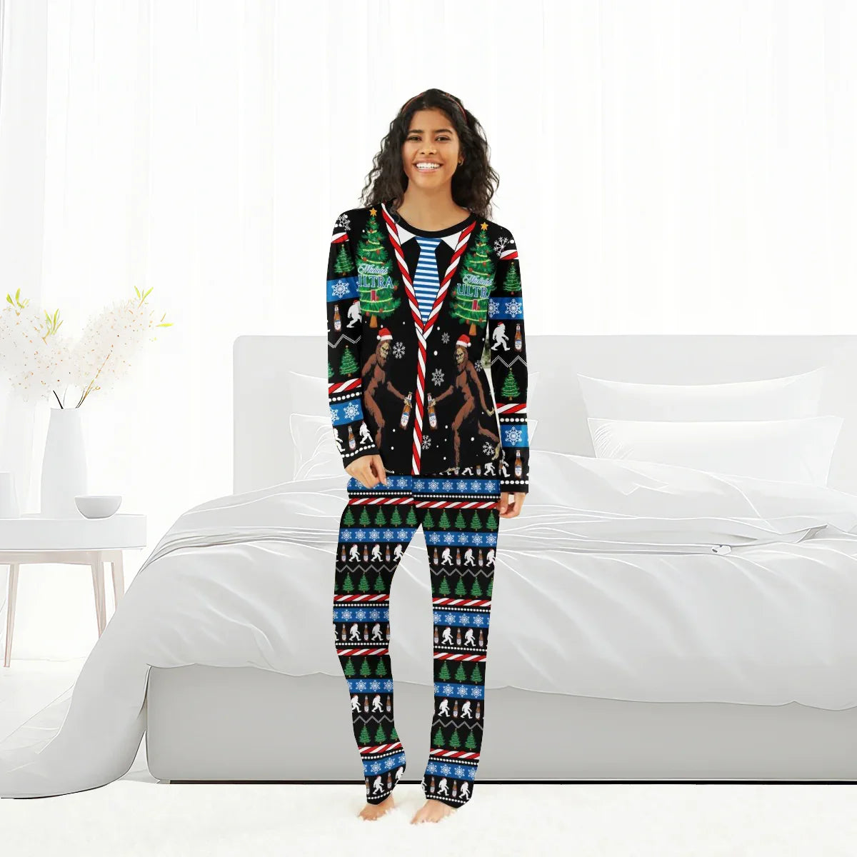 Smiling woman wearing Michelob Ultra Christmas Bigfoot pajamas with holiday trees and Santa Bigfoot design