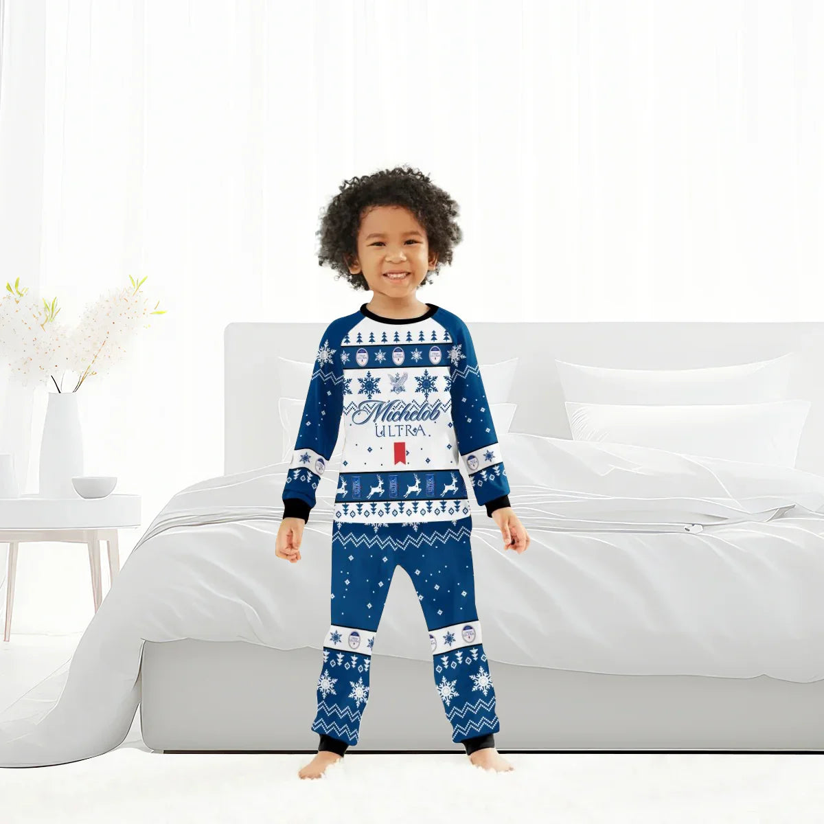 Smiling child in blue and white Michelob Ultra Christmas pajama set standing in bright modern bedroom