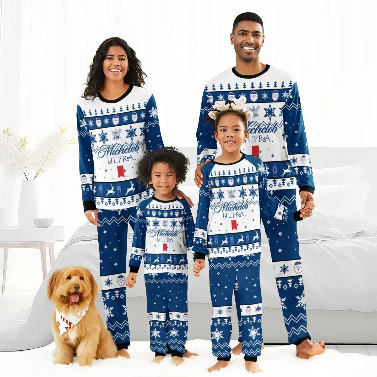 Family of four in matching blue Michelob Ultra Christmas pajamas with snowflakes and reindeer, smiling indoors with dog