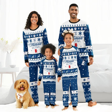 Family of four in matching blue Michelob Ultra Christmas pajamas with snowflakes and reindeer, smiling indoors with dog