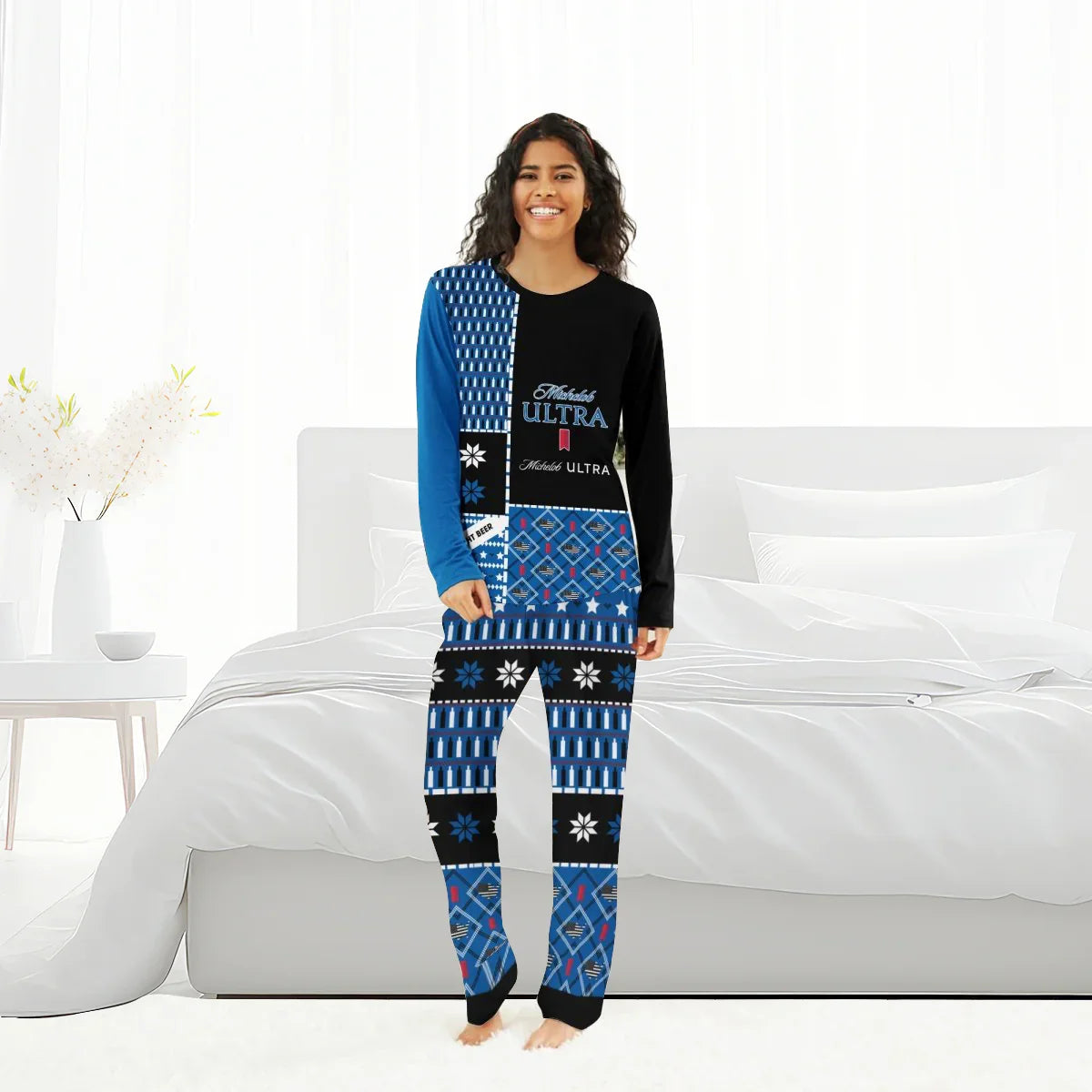 Smiling woman in blue and black Michelob Ultra family pajama set standing in bright modern bedroom