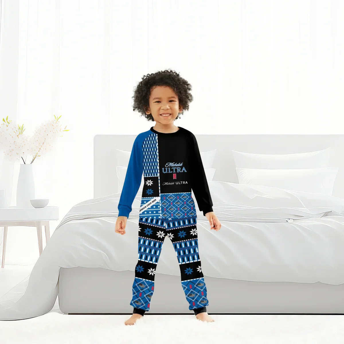 Smiling child in blue and black Michelob Ultra branded pajamas standing in bright modern bedroom