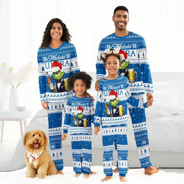 Happy family of four and dog wearing matching blue Michelob Ultra Grinch Christmas pajamas in bright bedroom