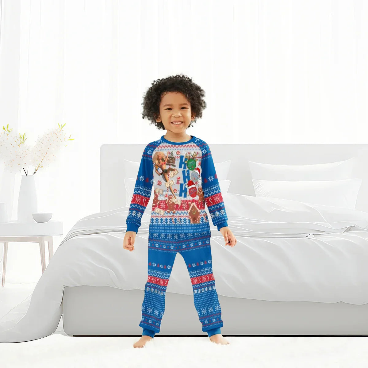 Smiling child wearing blue festive Christmas pajamas with holiday patterns and Ho Ho Ho text in bright bedroom
