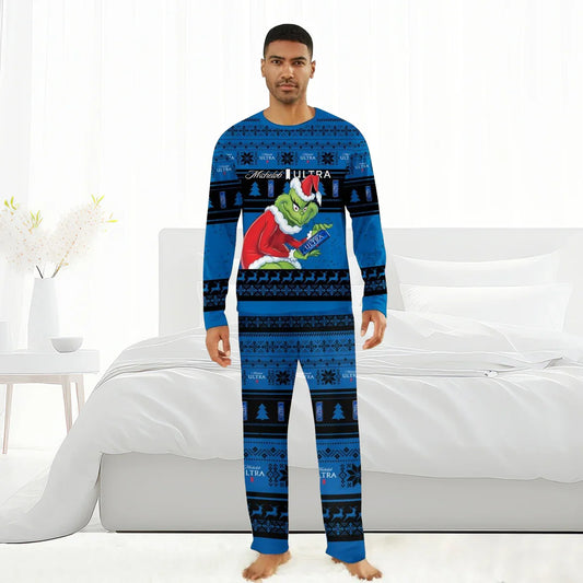 Man wearing blue Michelob Ultra Grinch themed Christmas pajamas standing barefoot in a modern white bedroom