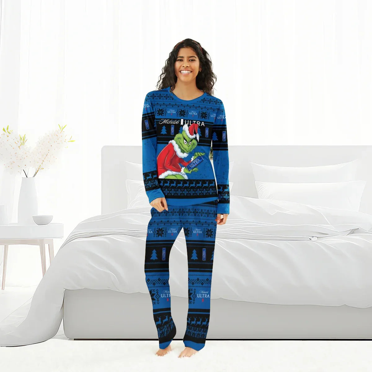 Woman wearing blue Michelob Ultra Christmas pajamas featuring the Grinch in a Santa hat holding a beer can