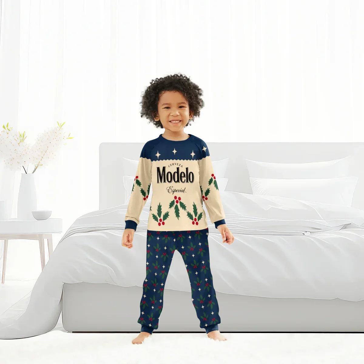 Smiling child in Modelo Christmas cherry family pajamas in bright white bedroom
